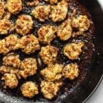 keto sausage and cheese stuffed mushrooms in a skillet