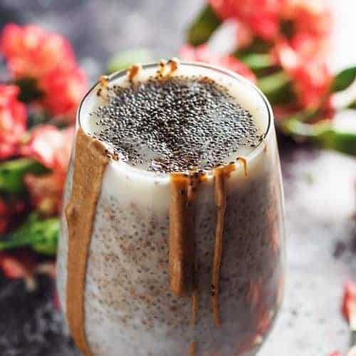 chia seeds pudding in a glass with flowers around
