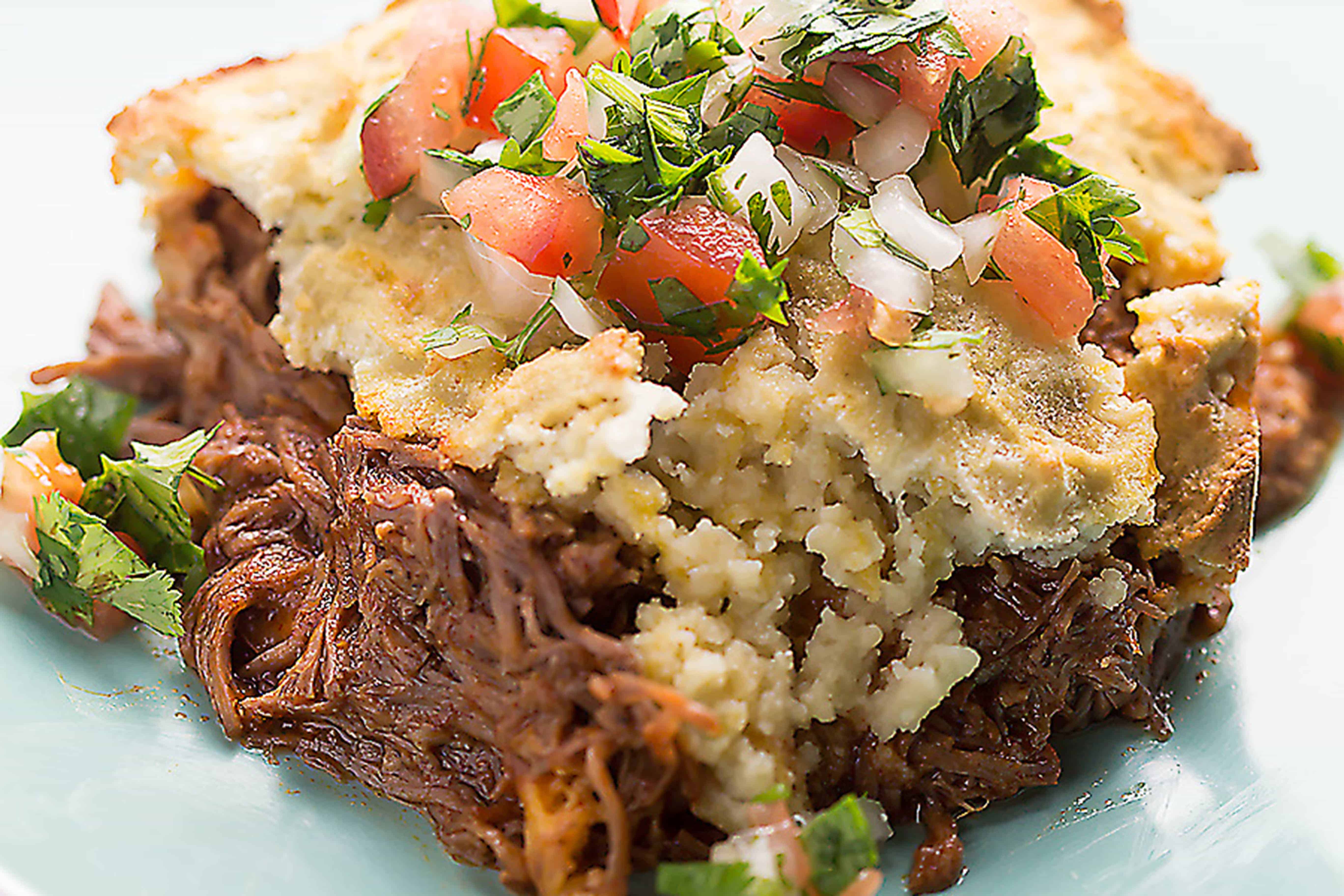 This low carb tamale pie is so full of flavor and gluten free! Saucy shredded beef, melty cheese, and a low carb "cornbread" crust.