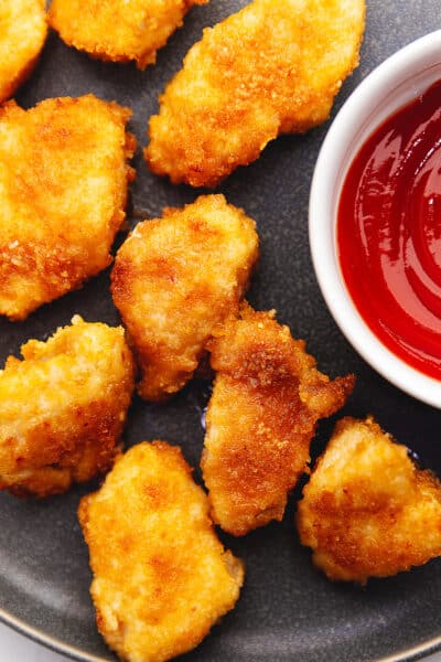 keto chicken nuggets on a dark gray plate with ketchup