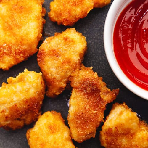 keto chicken nuggets on a dark gray plate with ketchup