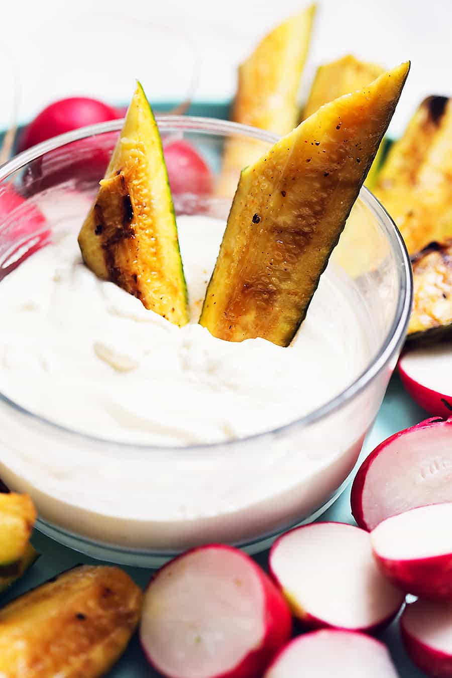 creamy feta dip in a glass bowl with roasted zucchini