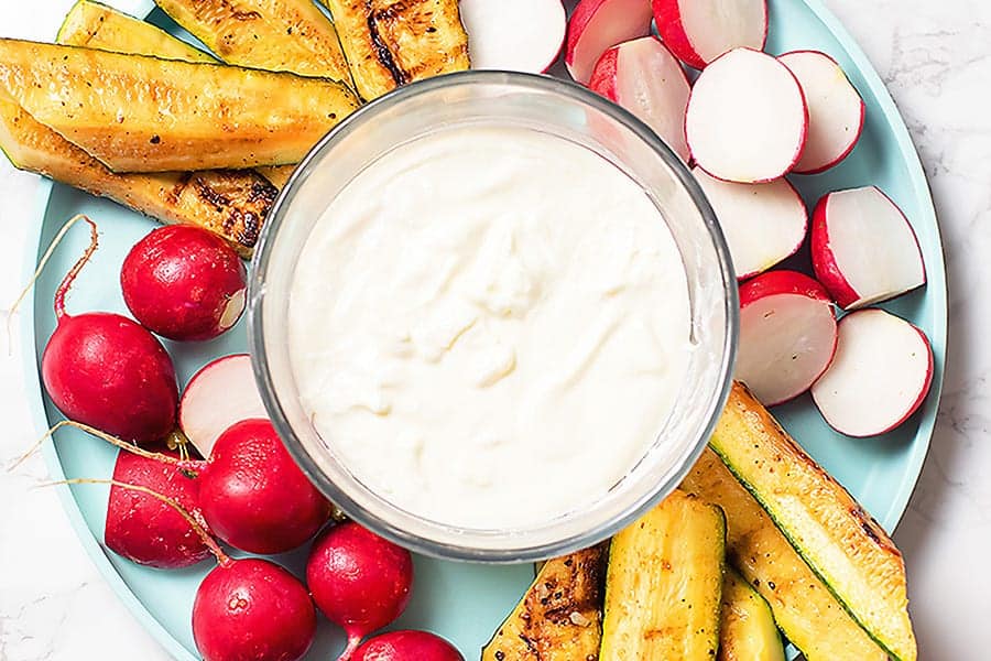 creamy feta vegetable dip on a blue plate