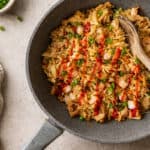 finished egg roll in a bowl topped with scallions and sriracha