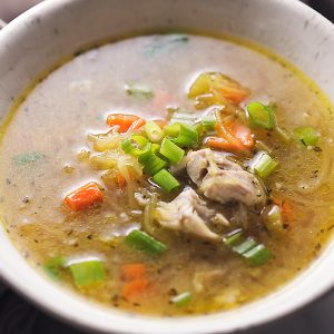 A bowl of low carb chicken noodle soup with green onion on top