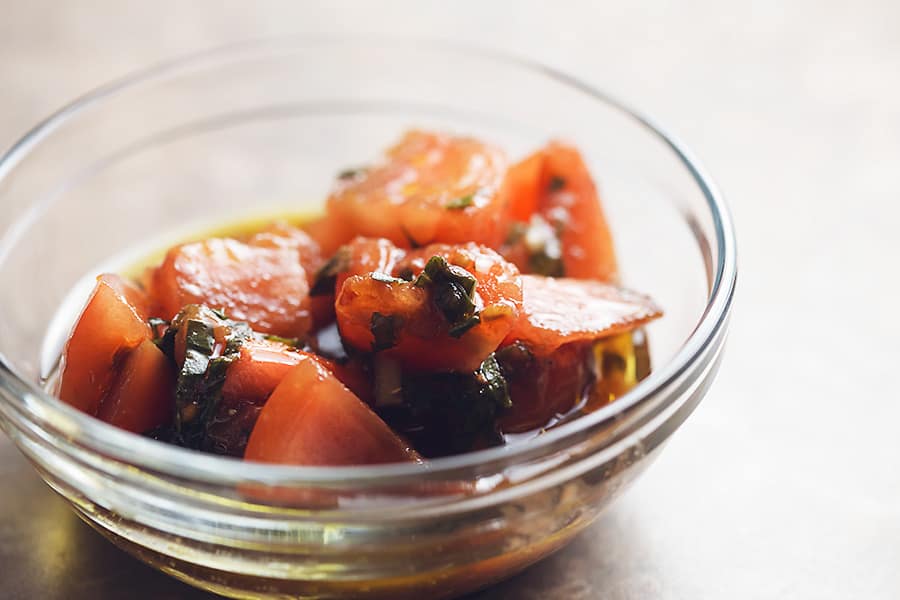marinated tomato salad in a glass bowl