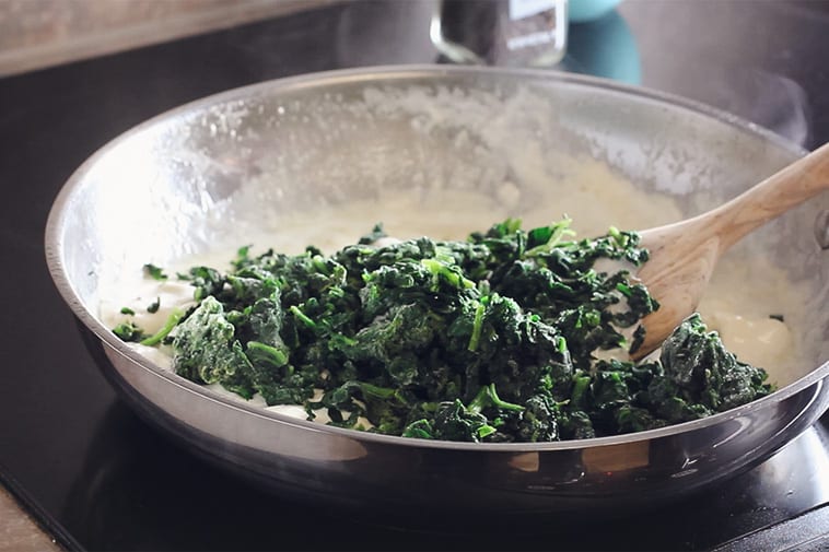 frozen spinach added to a skillet