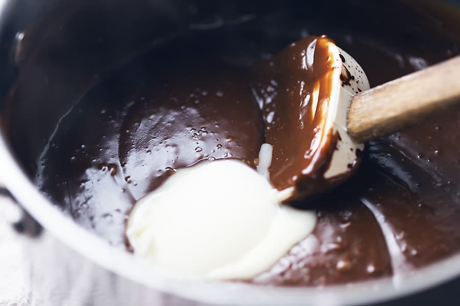 a sauce pan with homemade chocolate pudding and a spatula