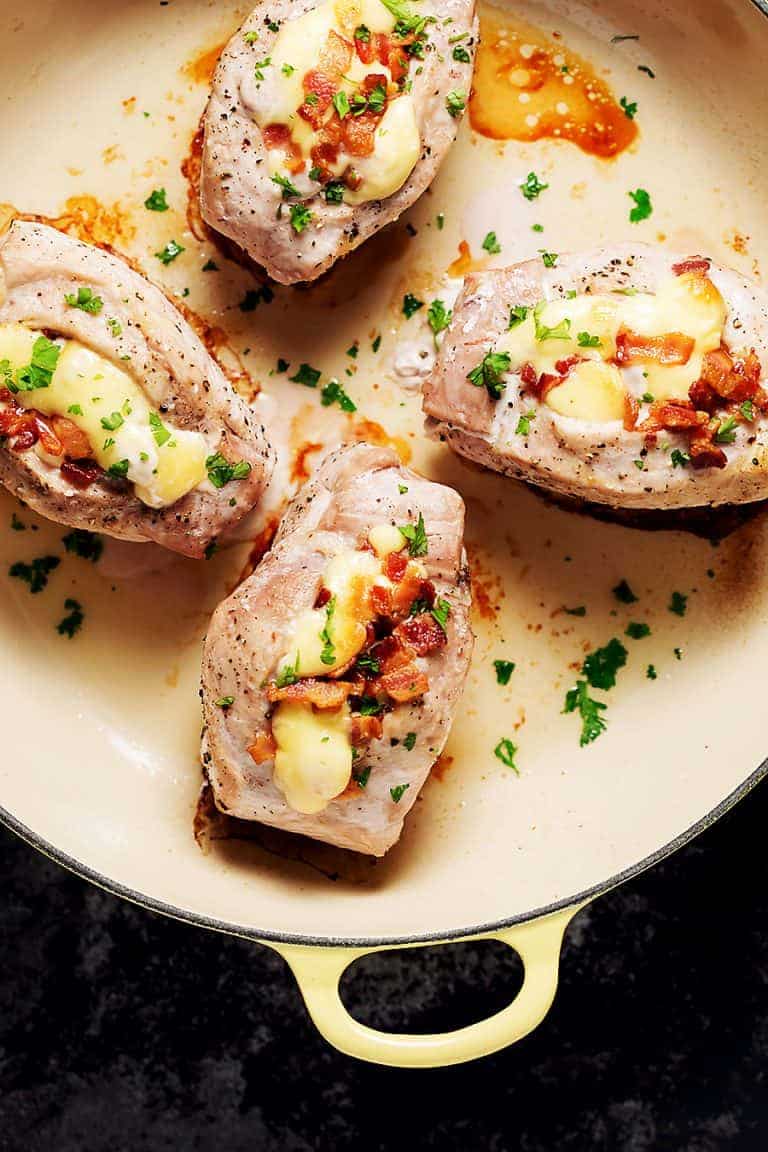 pork chops stuffed with bacon and gouda in a yellow saucier