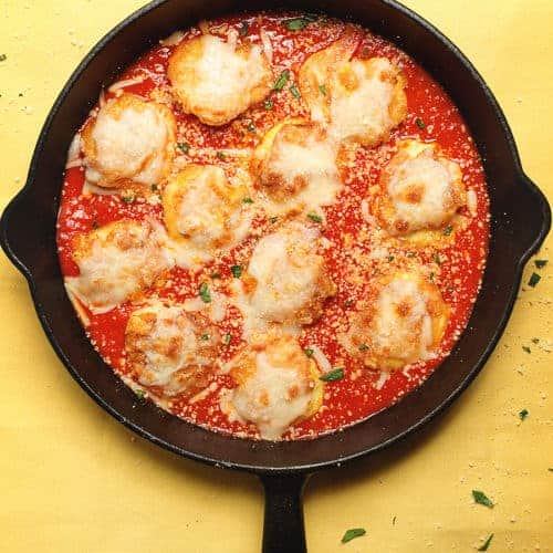 shrimp parmesan in a cast iron skillet on a yellow table cloth