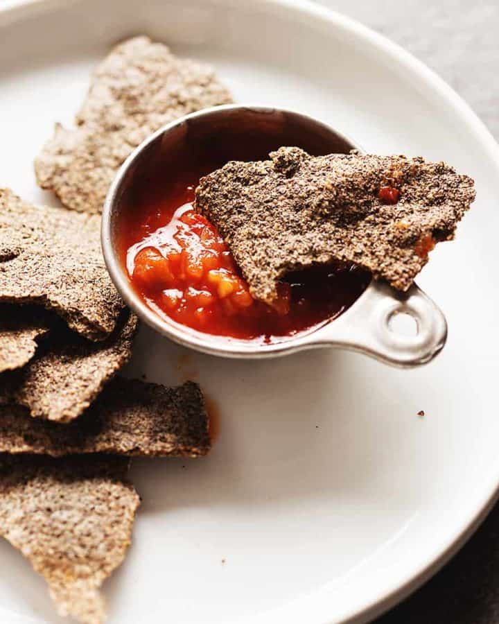 low carb tortilla chips on a white plate with salsa