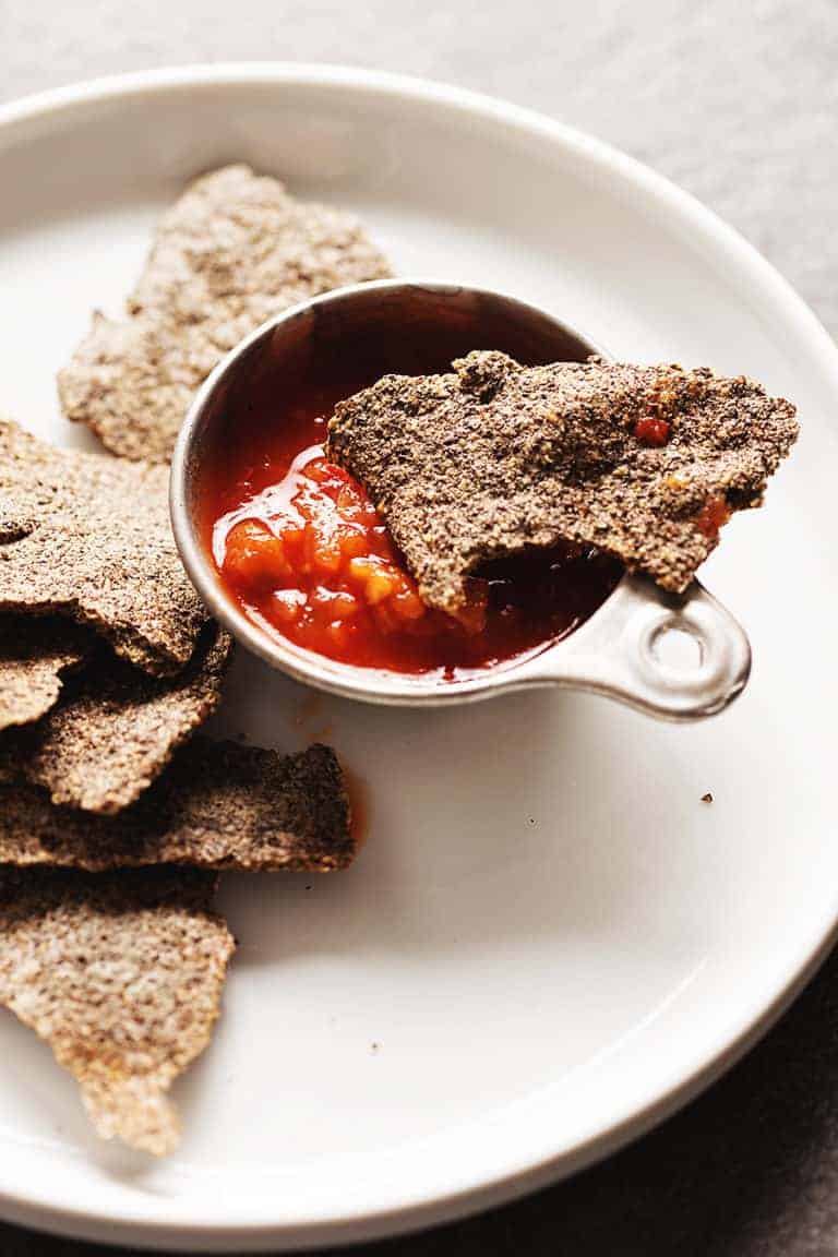 low carb tortilla chips on a white plate with salsa