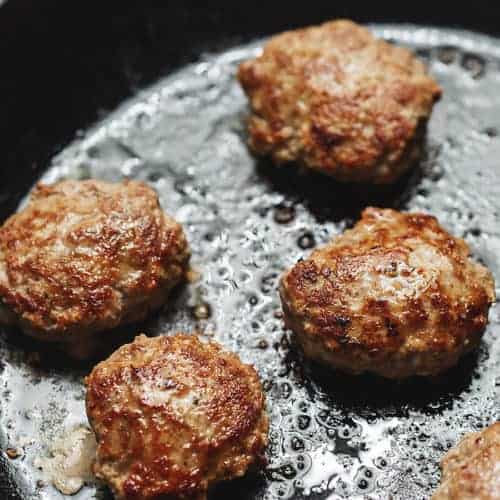 turkey sausage patties cooking in a skillet