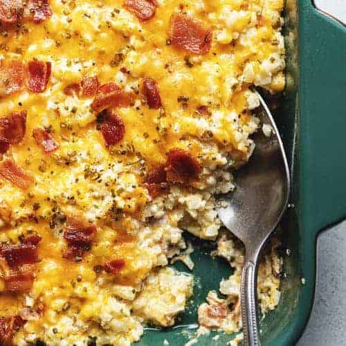 cheesy loaded cauliflower rice casserole in a green dish