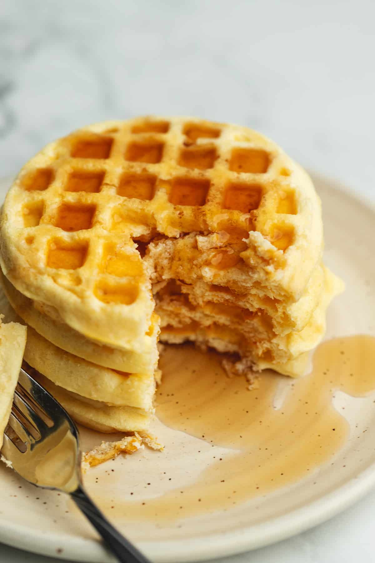 a stack of protein waffles with syrup