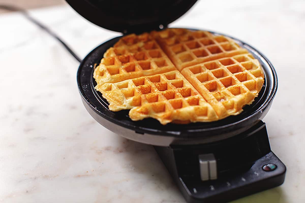 a waffle maker with a cooked waffle in it