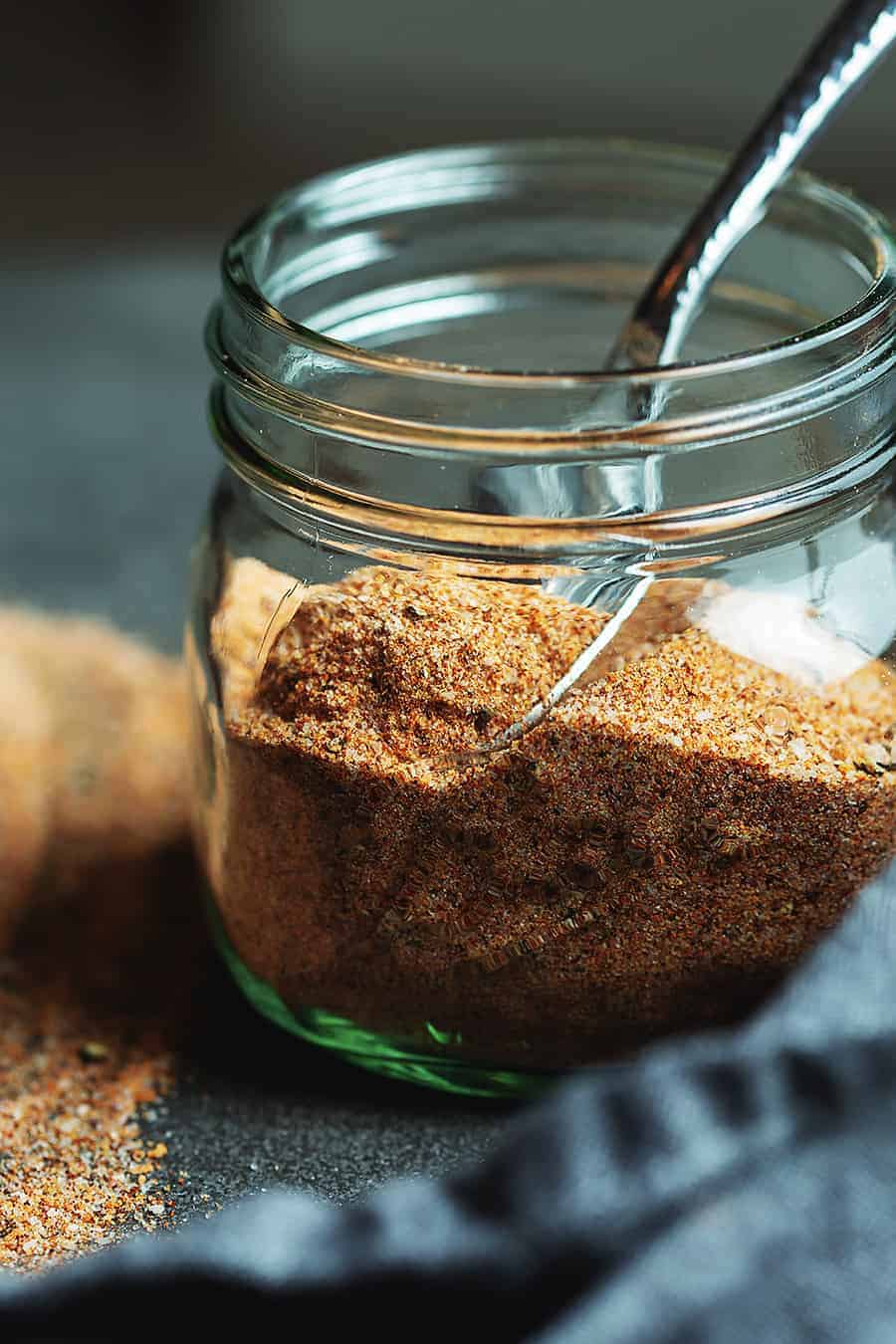 spices mixed together in a small jar with a spoon