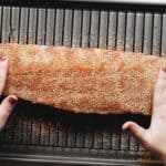 pressing bbq rib rub into a rack of ribs