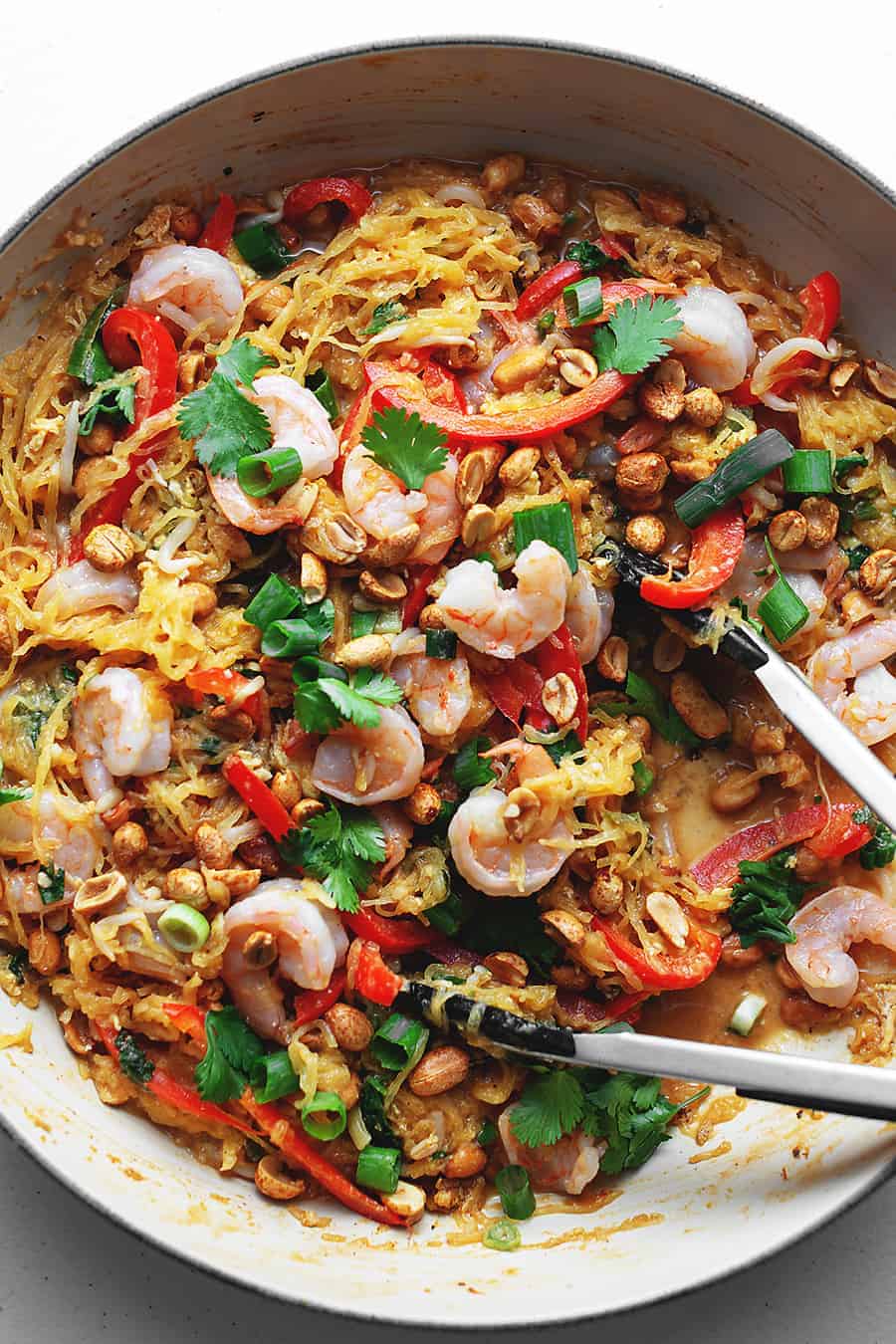 keto spaghetti squash pad thai with shrimp in a large skillet with tongs
