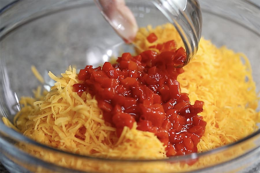 grated cheese in a bowl with diced pimentos
