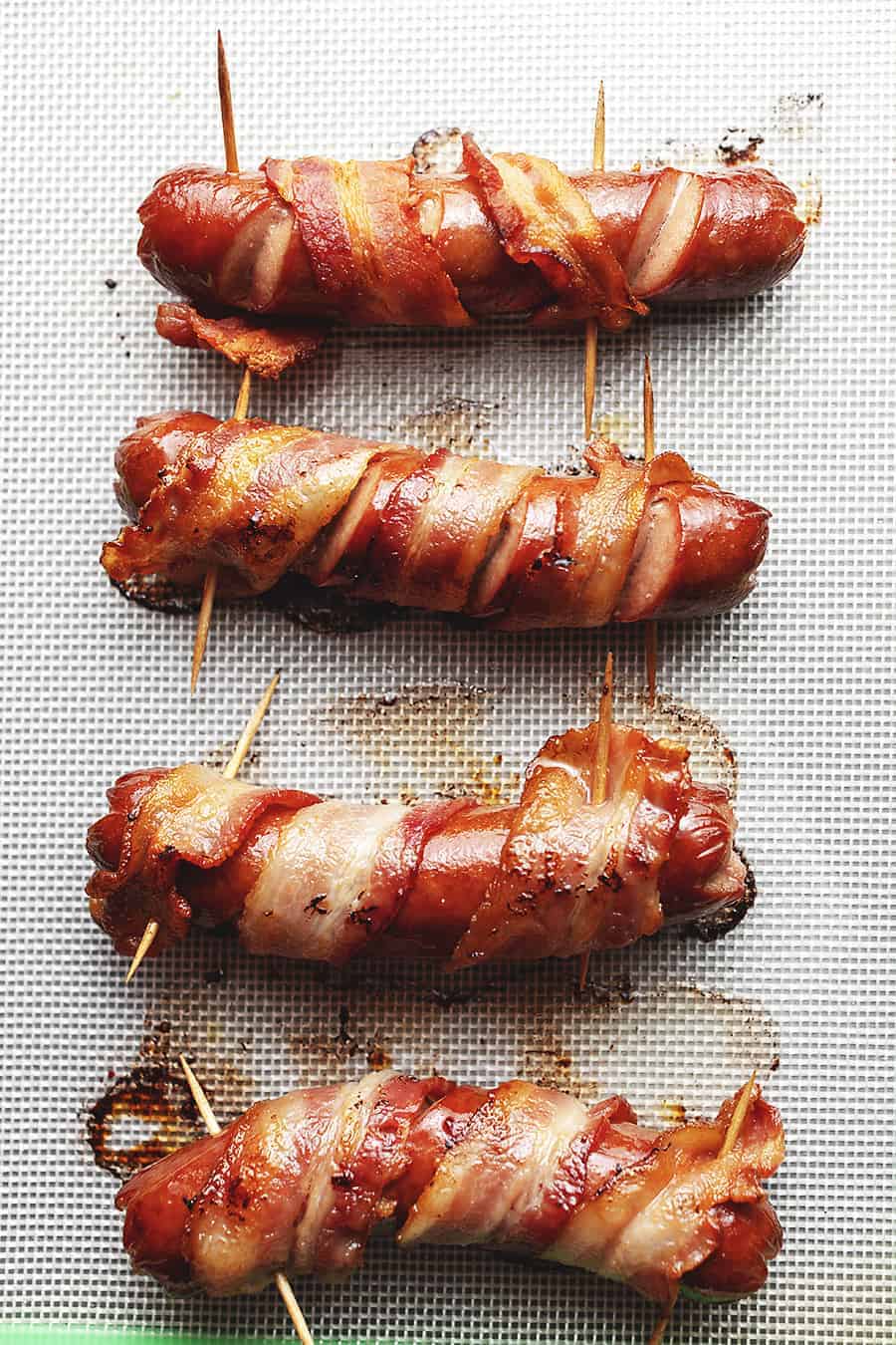 bacon wrapped hot dogs on parchment paper