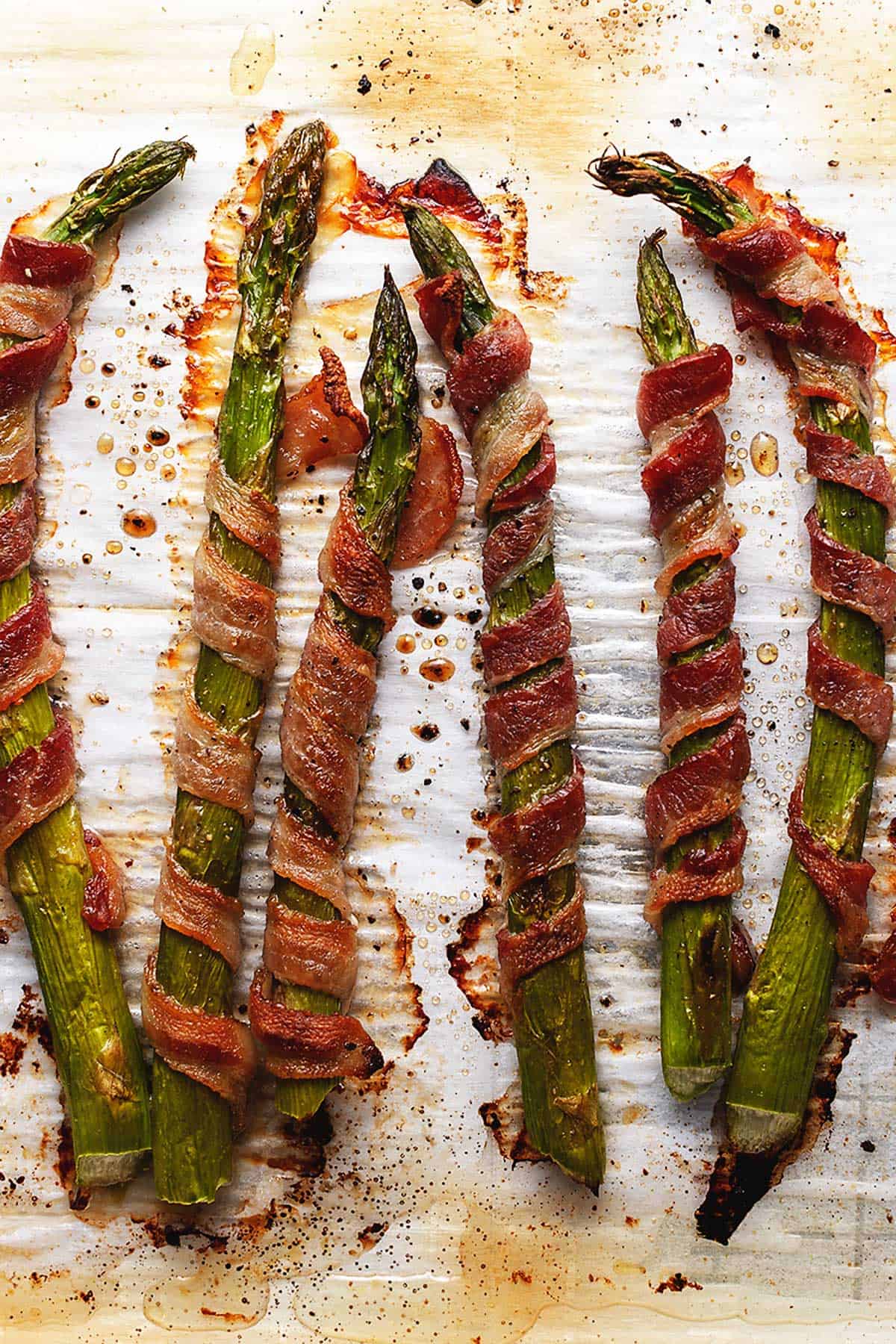 crispy bacon wrapped asparagus on parchment paper