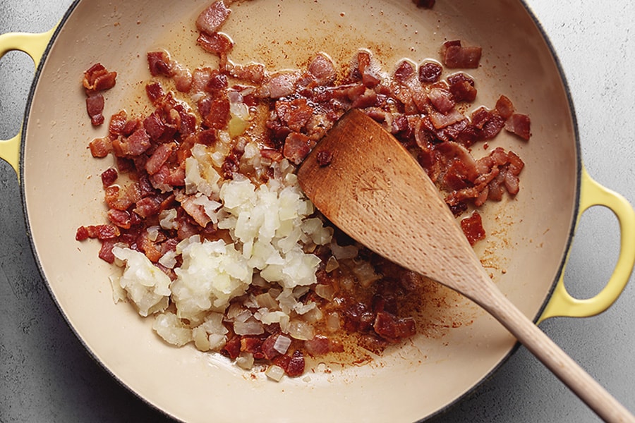 bacon and onion cooking in a skillet