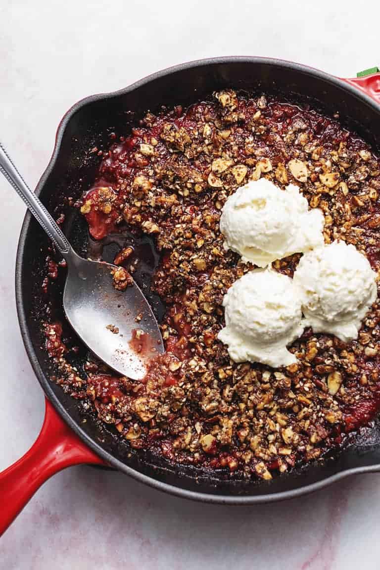 keto strawberry crisp in a skillet with ice cream
