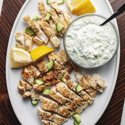 greek chicken with tzatziki on a white serving plate