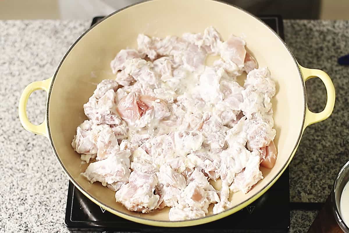 cooking marinated chicken in a skillet