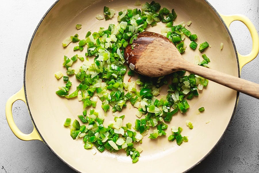 onions and peppers being sauté in a skillet for low carb pizza casserole
