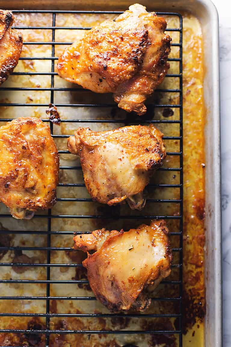 crispy chicken thighs on a sheet tray with a rack