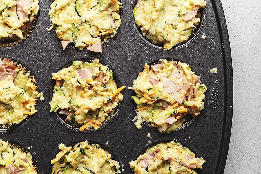 keto breakfast muffins in a muffin tin needing to be baked in the oven 