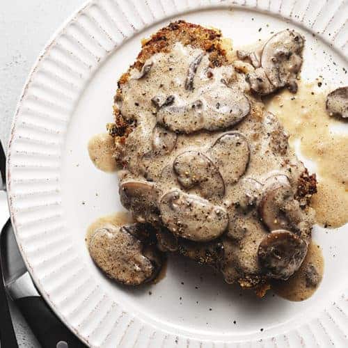 keto chicken fried steak with mushroom gravy on a white plate