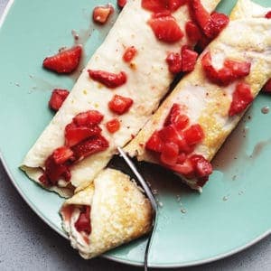 strawberry cream cheese stuffed crepes on a plate