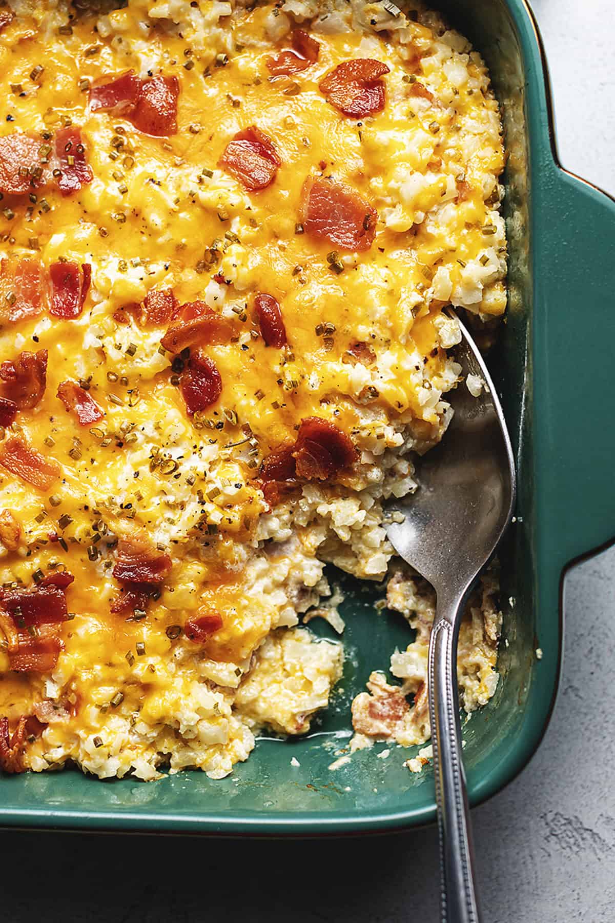 loaded cauliflower casserole in a green baking dish