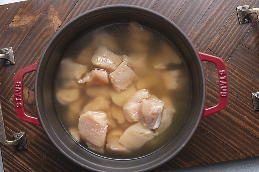 poaching chicken in chicken broth and a heavy bottom pot