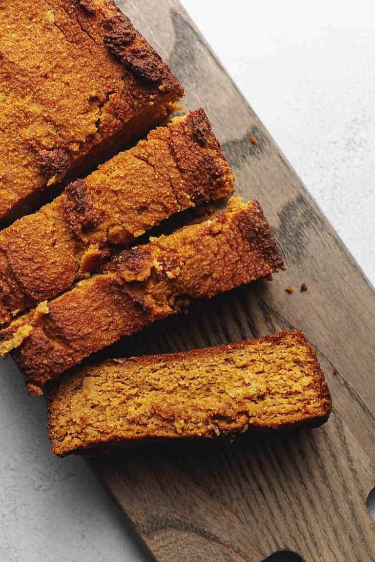 keto pumpkin bread sliced on a wood board