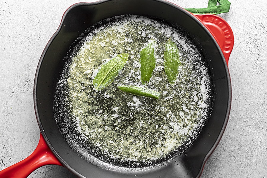 sage being cooked in butter with a skillet
