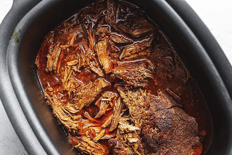 shredded balsamic London broil in a black crock pot 