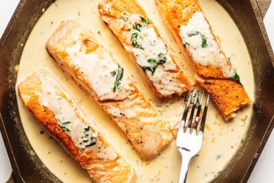 salmon with a creamy sauce in a skillet