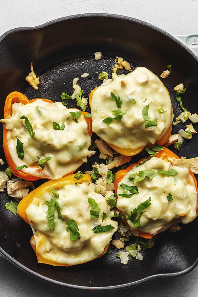 4 stuffed peppers with white cheese in a skillet