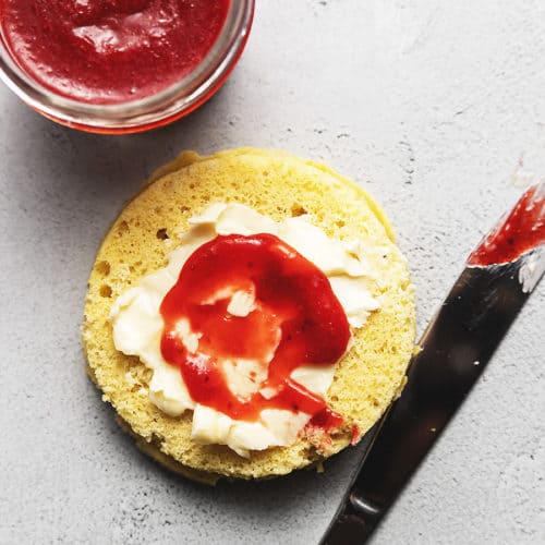 strawberry jam spread on bread with a butter knife