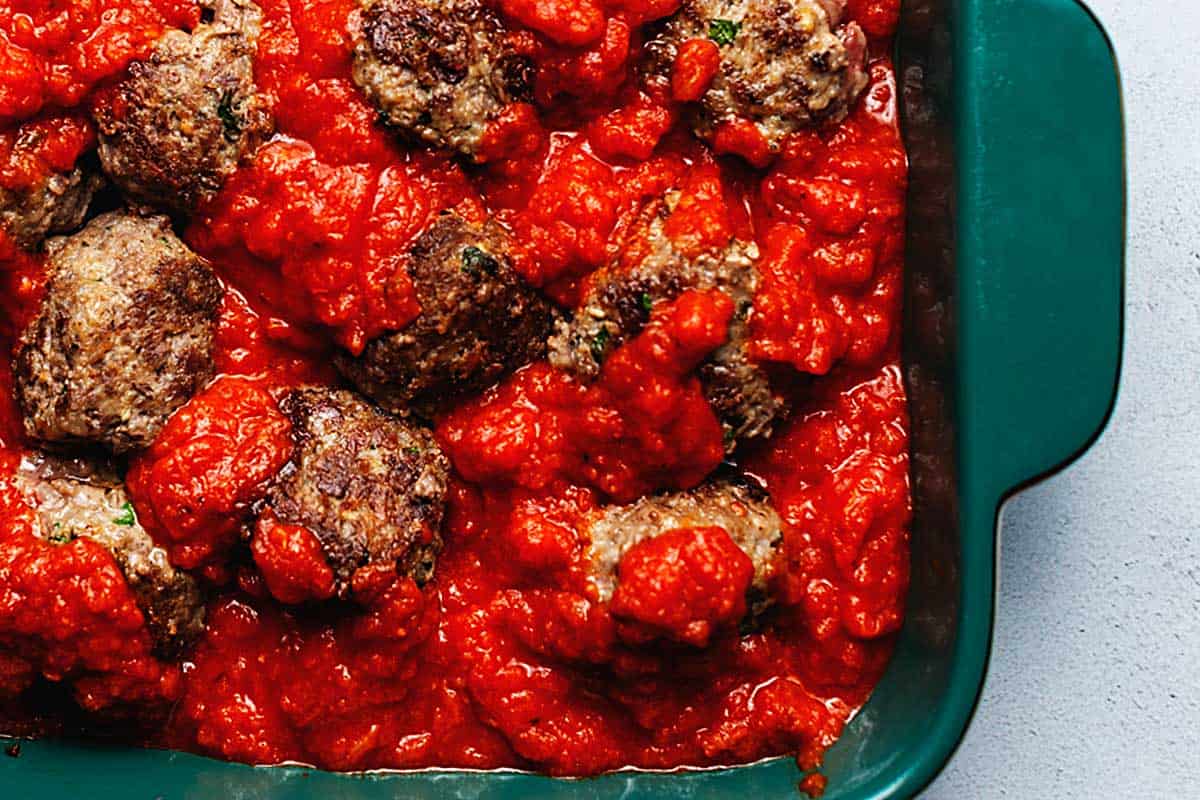 browned meatballs with keto marinara sauce in a casserole dish