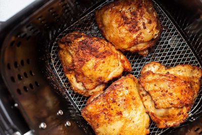 chicken thighs in an air fryer basket
