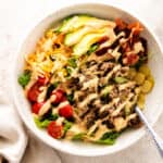 Cheeseburger salad with lettuce, seasoned beef, bacon, avocado, pickles, tomatoes, and creamy Big Mac dressing