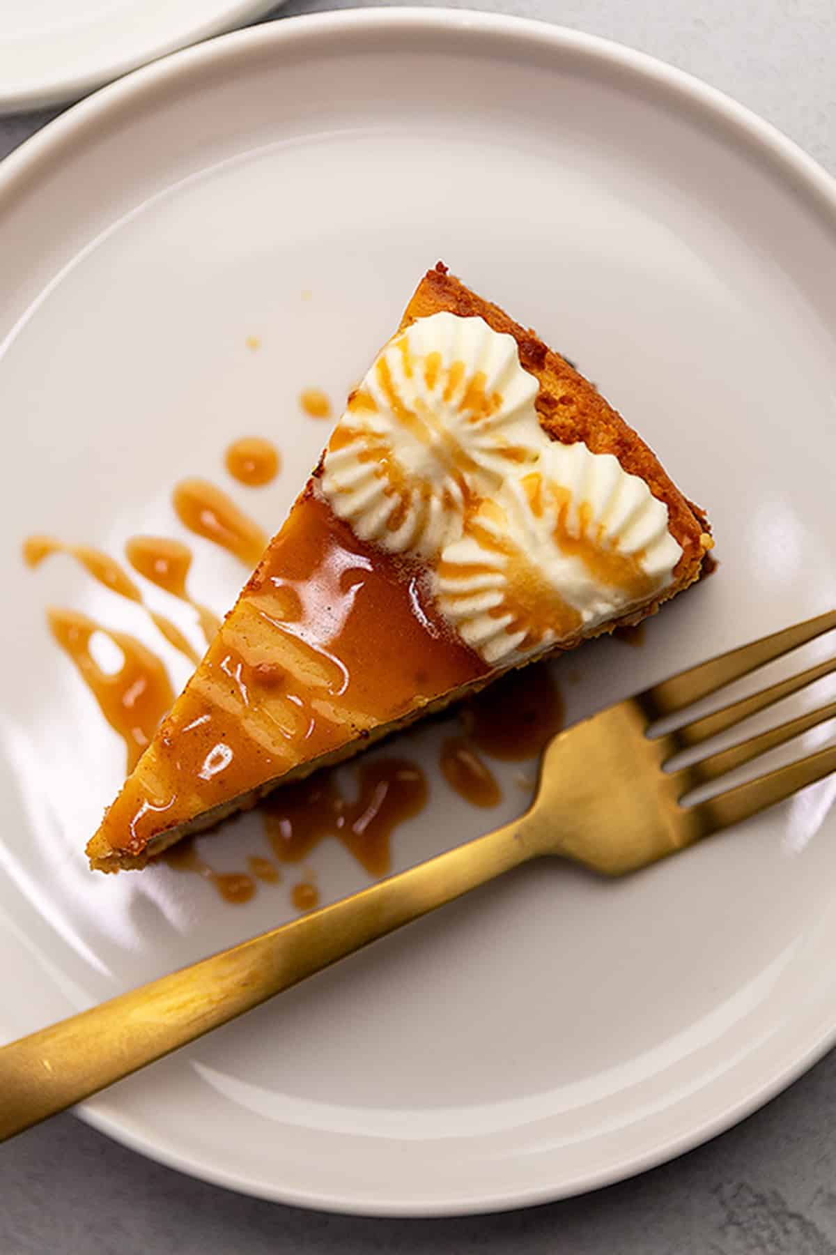 pumpkin cheesecake drizzled with caramel on a white plate