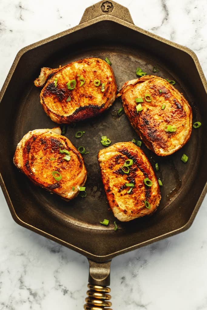 bacon wrapped pork chops in a skillet