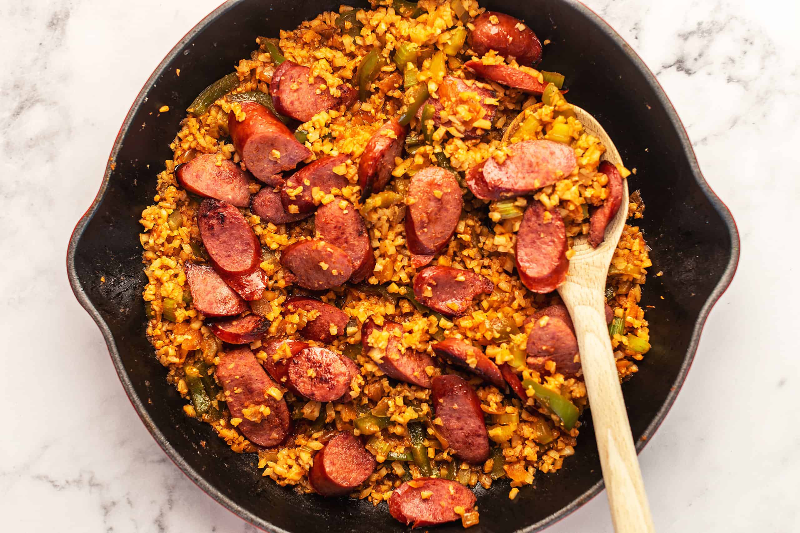 sausage and peppers in a red skillet