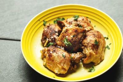 pressure cooker chicken thighs in a yellow bowl